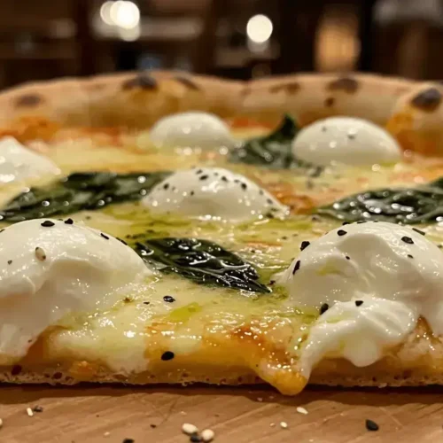 Stracciatella pizza with creamy cheese, fresh basil, and a golden crust.